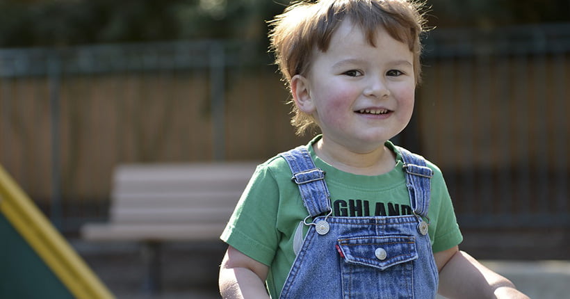 Young boy with autism smiling outside