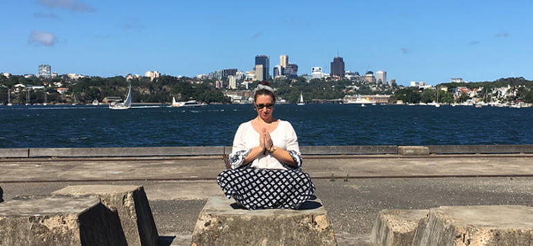 Woman sitting outside in the sun meditating