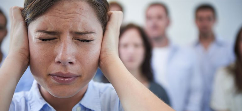 Girl with sensory hypersensitivity closing her eyes and covering her ears with her hands