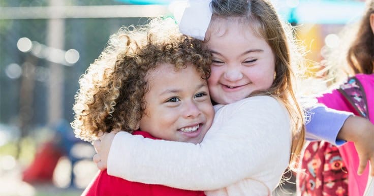 Girl hugging her sister with Down syndrome