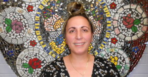 Lisa standing in front of a mosaic wall