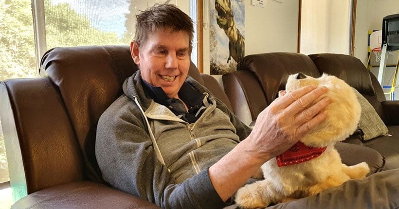 Kevin patting his support dog Goldie