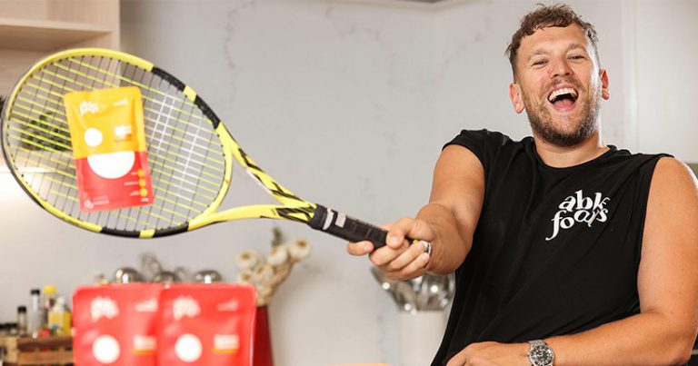 Dylan Alcott hitting a packet of baked beans with a tennis racquet