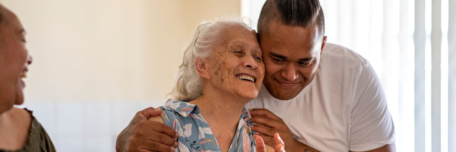 A man hugging an older women, both are smiling