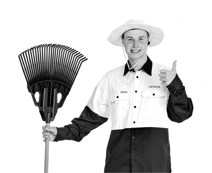 A supported employee holding a rake and giving a thumbs up, representing disability employment services