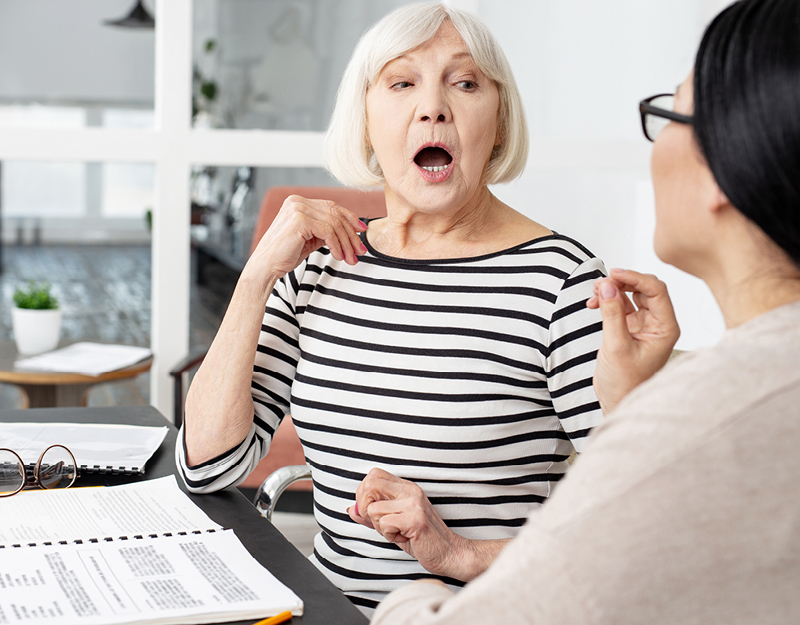 An adult participant working on speech techniques with a therapist during speech pathology services