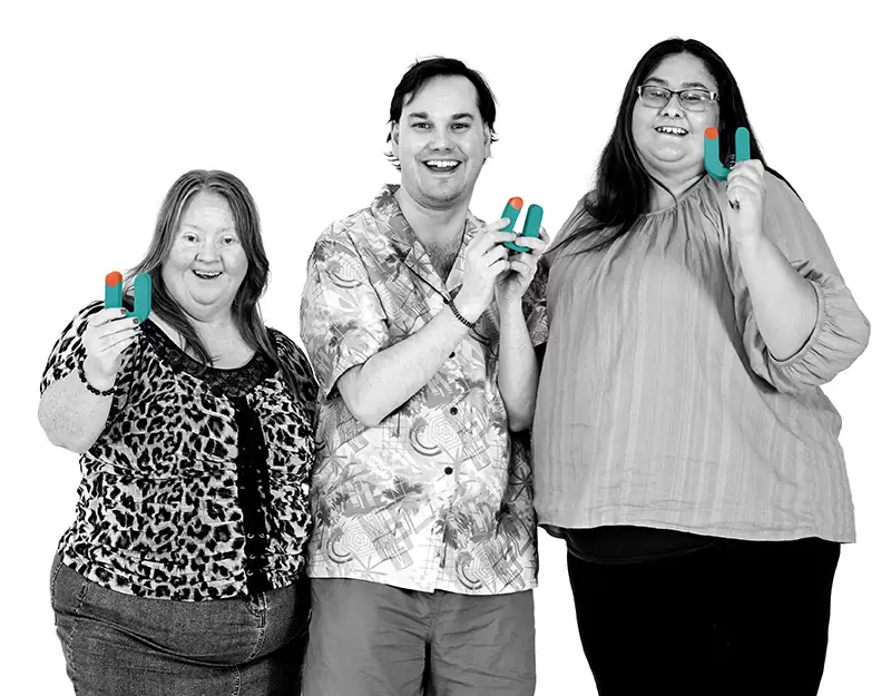 Three Aruma participants smiling and holding colourful Aruma logo letters