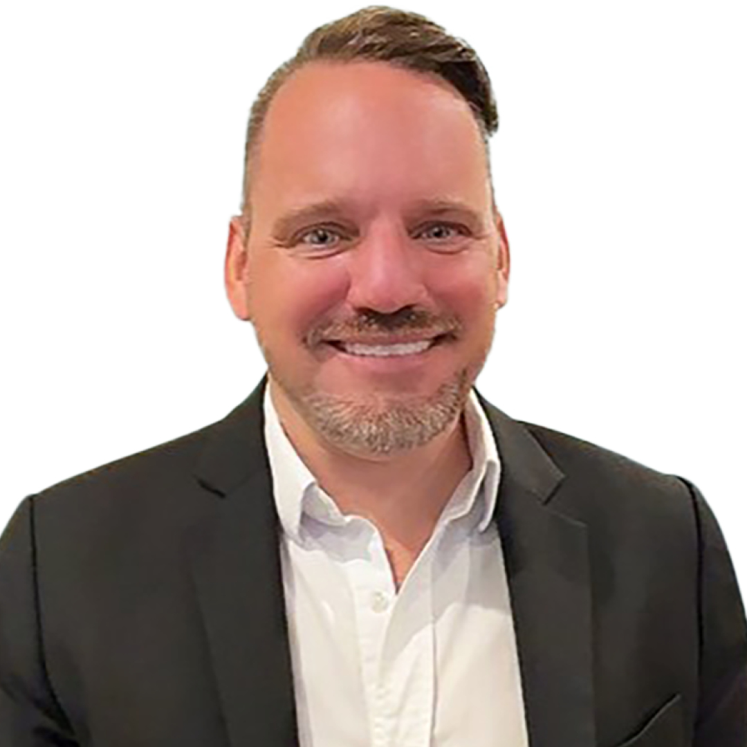 Elliot Dowling, Chief Transformation Officer, smiling broadly. He is wearing a dark blazer over a white open-collar shirt, with short styled hair and a goatee.