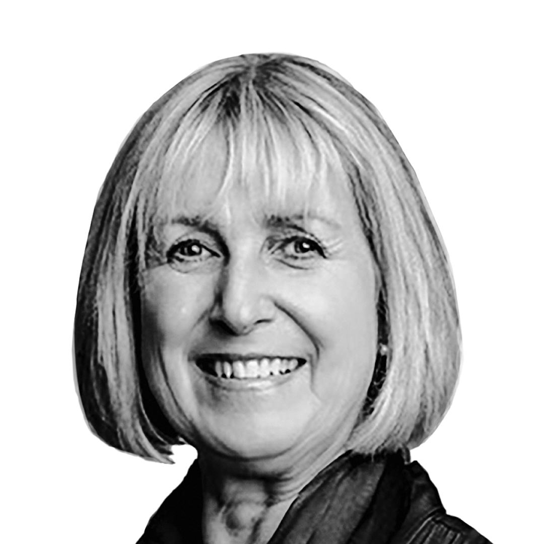 Black and white portrait of Dr Georgina Reynhout, Director, smiling warmly. She has a blonde bob with a fringe.