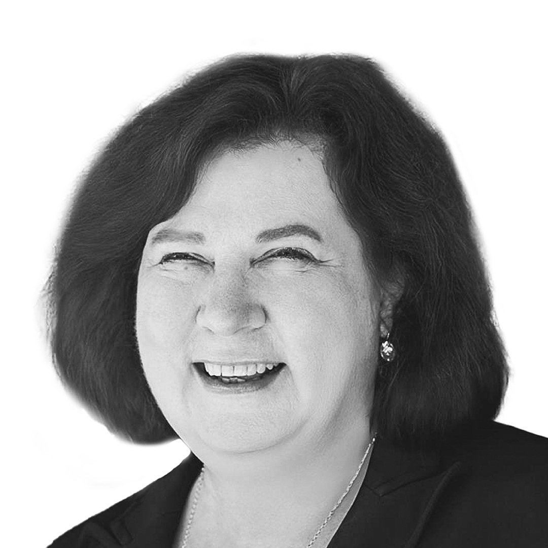 Black and white portrait of Liz Forsyth, Director, laughing warmly. She has shoulder-length dark hair and is wearing a dark jacket and delicate necklace.