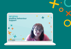 A computer screen with a still of the interview with Olivia shown on the screen. The text says "Aruma, positive behaviour support" and the background is teal.