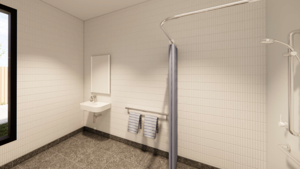 Render of an accessible ensuite bathroom inside a Ringwood East SDA home, showing a roll-in shower with curtain rail, wall-mounted basin with mirror, grab rail and non-slip tiled flooring.