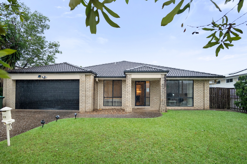 Front exterior of the Pacific Pines SIL home, a single-storey brick house with a double garage, tiled roof and front lawn.