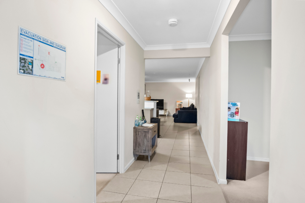 Hallway inside the Pacific Pines SIL home, with tiled flooring leading through to the living area.