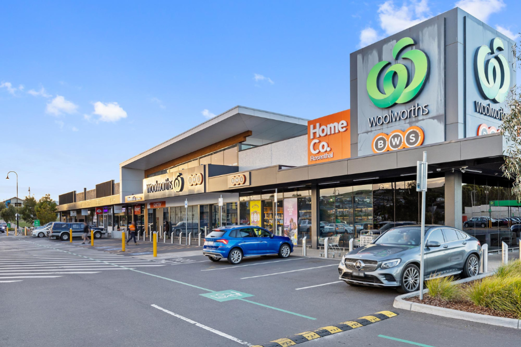 Nearby Woolworths and Home Co. shopping centre close to the Sunbury SDA home, showing the shopfront, car park with accessible parking spaces and BWS signage.