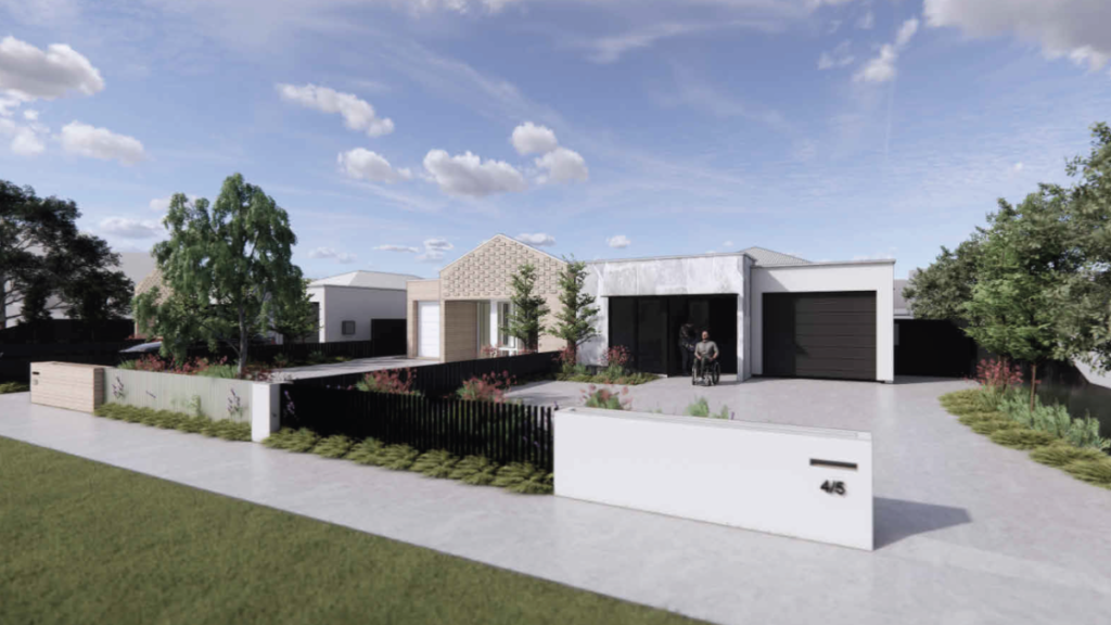 Street view of a Thomastown SDA home with a wheelchair user at the accessible front entrance, featuring modern rendered and dark-clad exteriors, landscaped native gardens, black fencing and a neighbouring dwelling visible in the background.