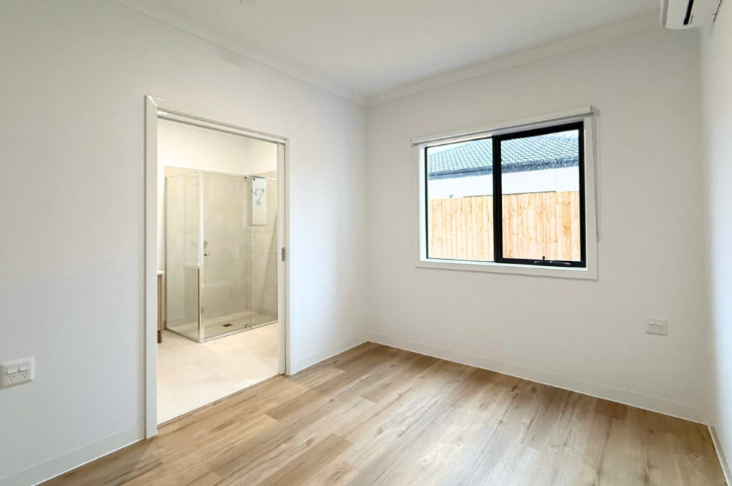 8. Bedroom inside the Sale SDA home, with built-in wardrobe and doorway opening to the private accessible ensuite.
