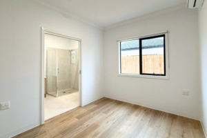 8. Bedroom inside the Sale SDA home, with built-in wardrobe and doorway opening to the private accessible ensuite.