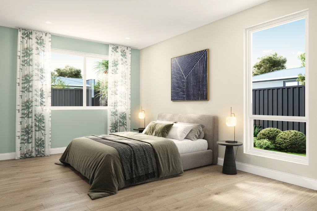 Bedroom inside the Wangaratta SDA home, showing timber-look flooring, sage green feature wall, large windows and a queen bed with soft furnishings.
