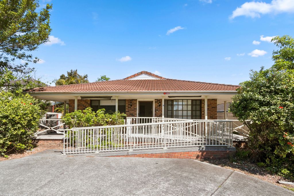 Front exterior of the Albion Park SIL home, a single-storey brick house with a tiled roof, covered front verandah and accessible ramp leading to the front entry.