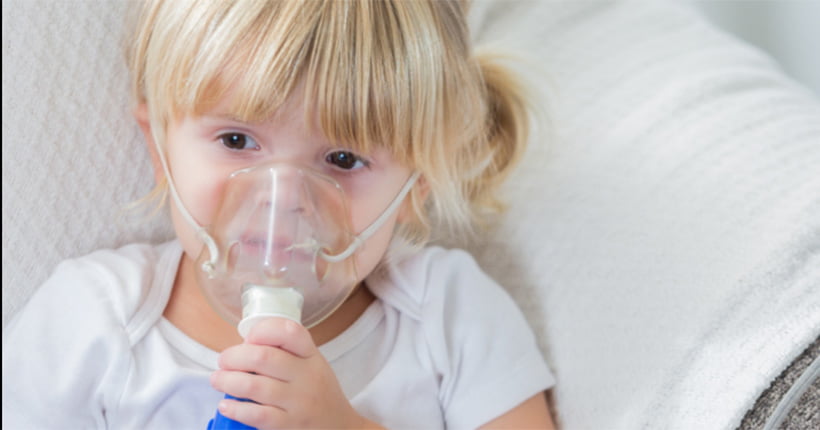 Girl with cystic fibrosis using a nebuliser