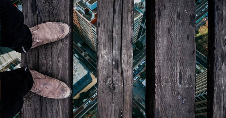 Photo looking at a person's feet standing on a high ledge