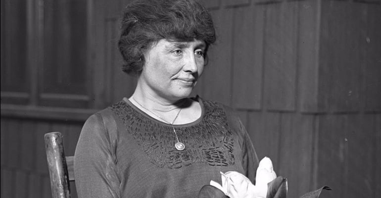 Helen Keller holding a flower