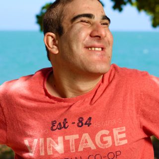 Man with a disability at the beach as part of a Community and Social Participation service at Aruma