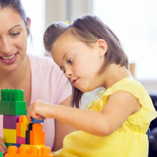 Support Worker and child with a disability playing with building blocks together