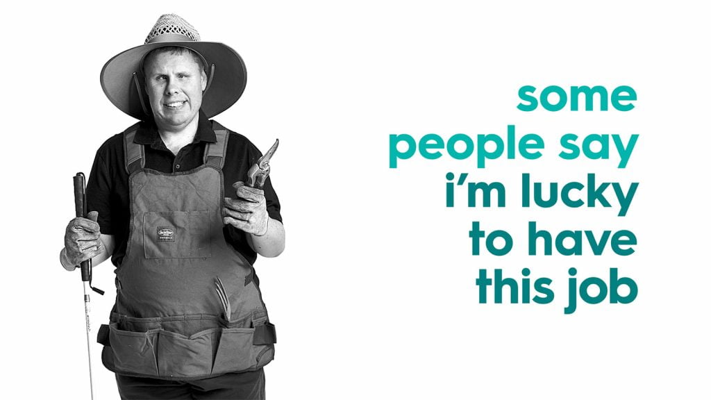 Man with a disability holding sheers and wearing a hat with the text 'some people say i'm lucky to have this job'