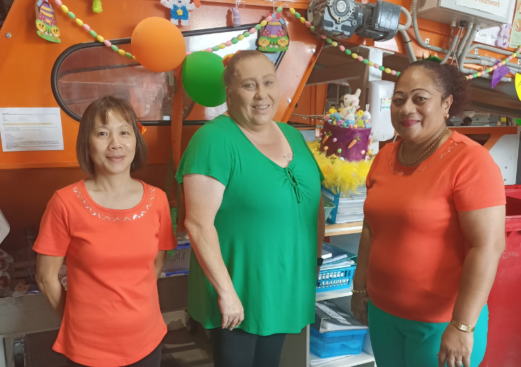 Three supported employees celebrating the 20th anniversary of the Warabrook Laundry