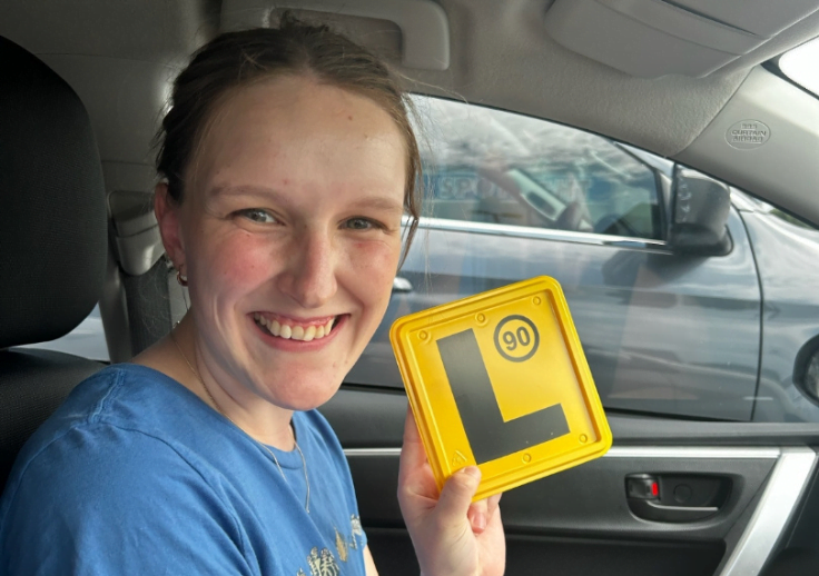 Our customer Chelsea proudly holding her new L plates after passing her driving test.