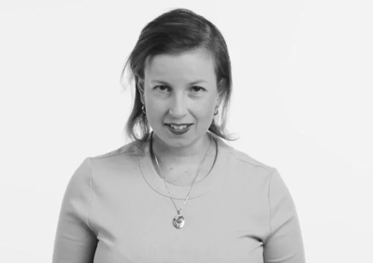 Elyce Shearer, one of Aruma's Human Rights Advisors posing with a big smile on her face in a black and white photograph.