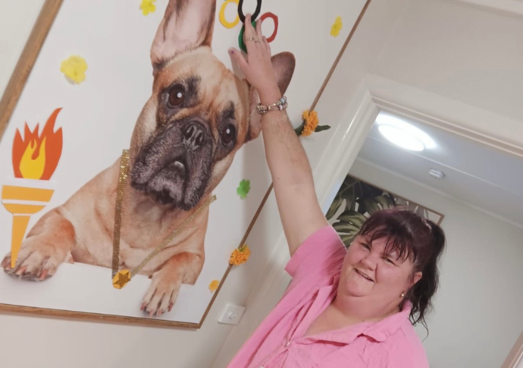 Aruma participant from Melbourne standing with her house mascot that is decorated for the olympics.